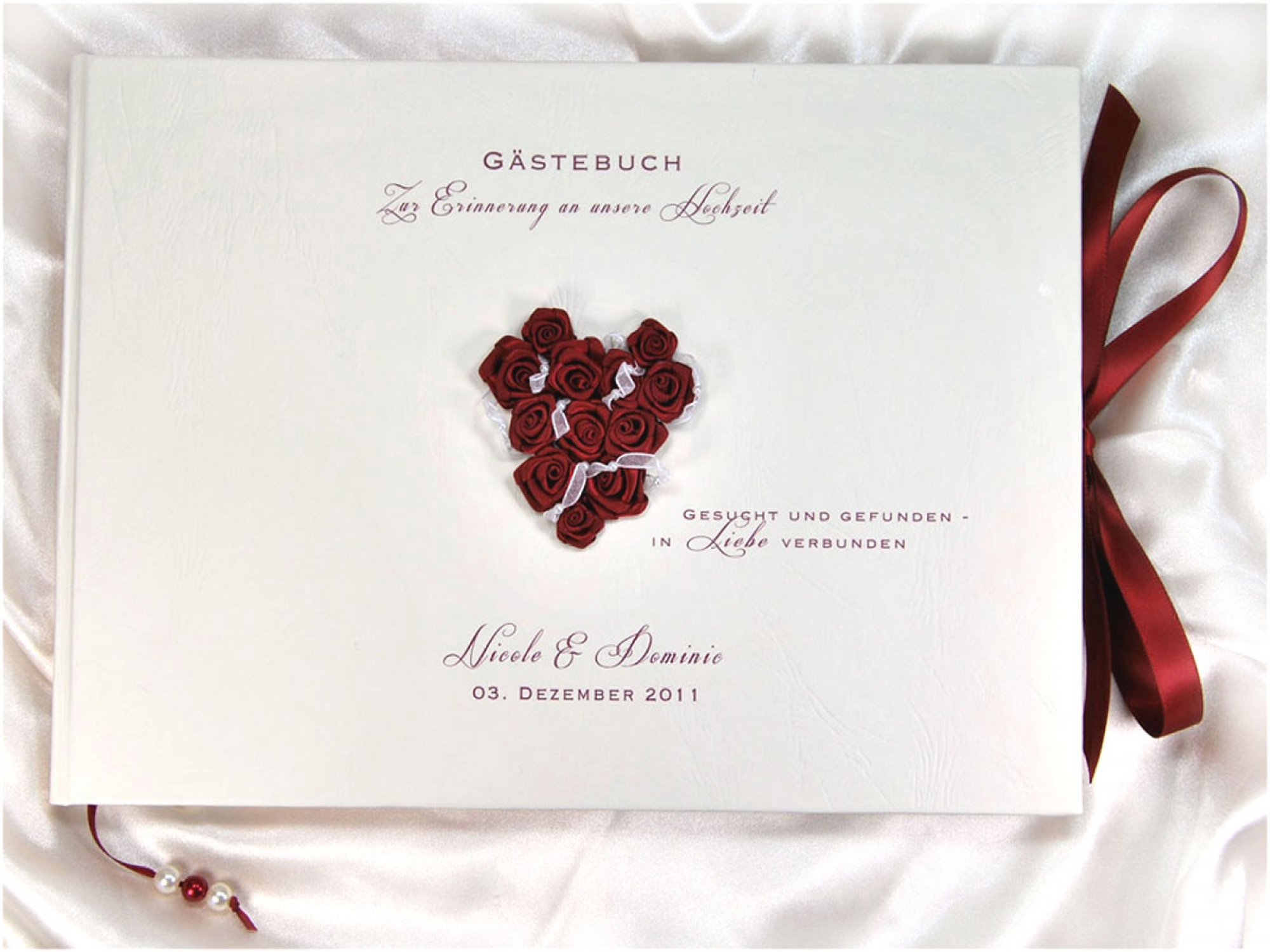 personalisiertes Gästebuch zur Hochzeit mit einem Herz aus Satinrosen in Bordeaux